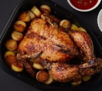 whole chicken grill with fried potatoes on dark  background