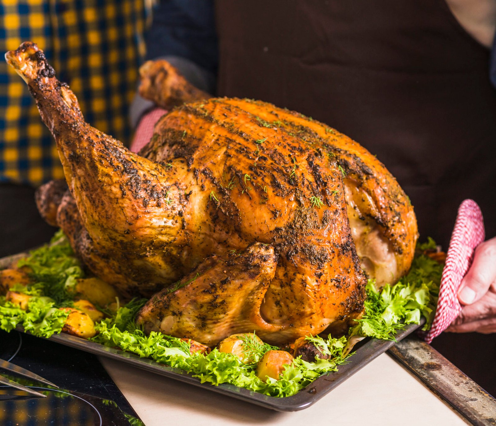 human-hand-holding-tray-with-roasted-ham